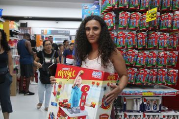 São Paulo (SP), 19/12/2023 - A artesão Ingrid Souza da Silva compra presentes para os filhos no comércio da rua 25 de Março. Foto: Rovena Rosa/Agência Brasil